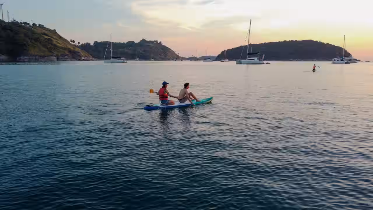 Men on Paddle Board on Sea Coast at Sunset